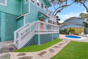 a blue house with a staircase and a yard at 1 Egret Street N Forest Beach in Hilton Head Island