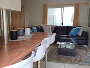 a living room with a wooden table and a couch at NJ WINDHOEK VILLA MANZi in Windhoek
