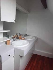uma casa de banho branca com 2 lavatórios e um espelho em Maison de ville em Déols