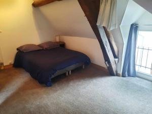 um quarto com uma cama com lençóis azuis e uma janela em Maison de ville em Déols