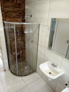 y baño con ducha y lavamanos. en ABSOLUTE AIRBNB en Windhoek