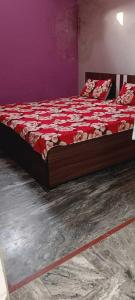 1 dormitorio con 1 cama con edredón rojo en SPOT ON Hotel Golden Gajraula, en Gajraula