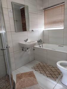 Baño blanco con lavabo y aseo en ABSOLUTE AIRBNB en Windhoek