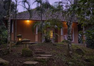 a house with a pathway in front of it at night at Rain Clouds Wayanad Forest Retreat - The Best Couple Friendly Private Cottages with Bathtub in Wayanad