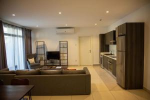 a living room with a couch and a kitchen at Cantonments Beautiful 2 Bedroom Apartment in Cantonments