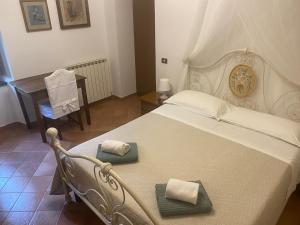 een slaapkamer met een wit bed en 2 handdoeken bij Affittacamere Nonna Rosa in Vallo di Nera