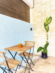 uma mesa de madeira com duas cadeiras e uma planta em Homestay Temerloh with private pool, Yhc Homestay em Temerloh