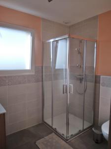 a shower with a glass door in a bathroom at Chez Nelly in Versaugues