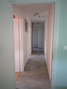 a hallway with pink walls and a long hallway with white walls at Chez Nelly in Versaugues