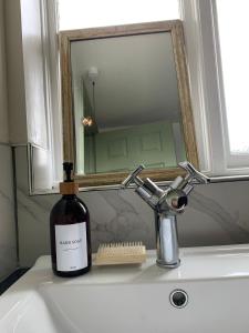 una bottiglia di vino seduta su un lavandino di fronte a uno specchio di Hidden gem in heart of Breckland a Watton