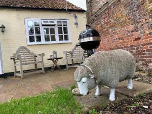 una estatua de una oveja parada al lado de un edificio en Hidden gem in heart of Breckland, en Watton