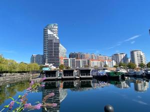 un perfil urbano con edificios y barcos en el agua en Morden 2bed2bath London Zone2 City/River View Home, en Londres