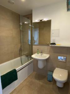 y baño con lavabo, aseo y ducha. en Morden 2bed2bath London Zone2 City/River View Home, en Londres