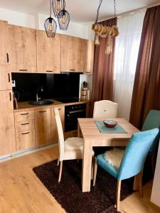 a kitchen with a wooden table and chairs and a sink at Vila Jahor CozyPlace 28 in Jahorina
