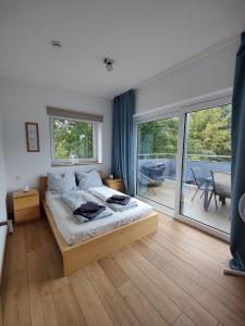1 dormitorio con 1 cama y balcón en Plüschmors, en Wittmund