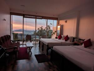ein Hotelzimmer mit 2 Betten und einem Balkon in der Unterkunft Nilowin Glenanore Guesthouse in Haputale