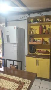 a kitchen with a refrigerator and a table and a shelf at Pousada Boqueirão in Passo Fundo