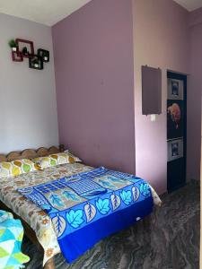 een slaapkamer met een bed en een tv aan de muur bij Malgudi Homestay in Someshwar