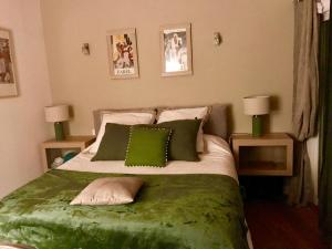 a bedroom with a bed with green sheets and pillows at VILLA SANTONI in Grosseto-Prugna