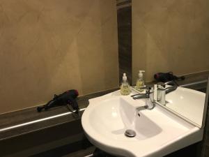 a bathroom with a white sink and a mirror at VILLA SANTONI in Grosseto-Prugna