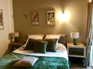 a bedroom with a bed with green and white pillows at VILLA SANTONI in Grosseto-Prugna