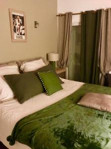 a bedroom with a green blanket on a bed at VILLA SANTONI in Grosseto-Prugna