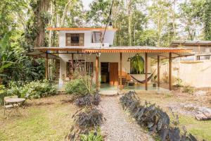 ein Haus im Wald mit Hängematte im Hof in der Unterkunft Casa Mazam in Talamanca