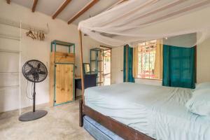 a bedroom with a bed and a fan at Casa Mazam in Talamanca