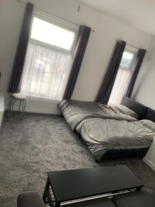 a bedroom with a bed and two windows at New 2 bedroom Apartment in Greater Manchester in Ashton under Lyne