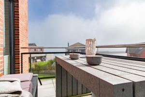 a wooden deck with two bowls on top of a balcony at Auf der Ostsee - am Meer - Olpenitz - by Unsere Urlaubszeit in Olpenitz