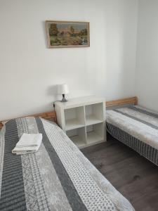 1 dormitorio con 2 camas y mesita de noche entre ellas en Pokoje_Zbąszyń, en Zbąszyń