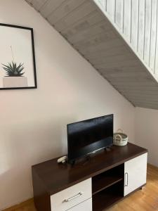 a flat screen tv sitting on a cabinet under a staircase at Domek Retro Karłów - Brda in Kudowa-Zdrój