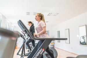 two girls on a treadmill in a gym at Schwarzwald Wellnesshotel SAIGERHÖH I Spa Golf & Wandern über dem Titisee in Lenzkirch