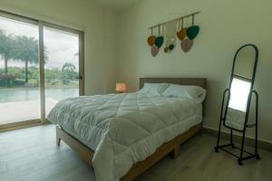 a bedroom with a large bed and a large window at Villa Cala Marina + Jacuzzi in Colón
