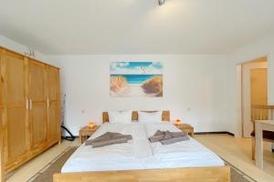 a bedroom with a large white bed and a table at An den Kreischen 28 Ferienbungalow Engel in Ueckeritz