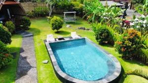 een uitzicht over het zwembad in de tuin bij Pondok sari homestay in Ungasan
