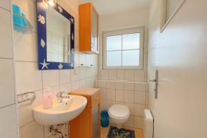 a bathroom with a sink and a toilet and a mirror at Ferienhaus Anja 3 in Ueckeritz +20 photos