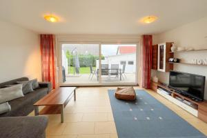 a living room with a couch and a tv at An den Kreischen 28 Ferienhaus Engel in Ueckeritz