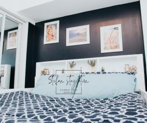 Stefan Staycation @ Azure North في سان فيرناندو: غرفة نوم مع سرير وبجدار لكنة سوداء