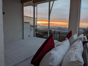 1 dormitorio con cama con almohadas en el balcón en Nilowin Glenanore Guesthouse, en Haputale