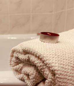 ein weißes Handtuch mit einer Tasse auf der Badewanne in der Unterkunft Idyllisches Ferienhaus in Siófok
