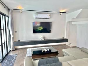 uma sala de estar com um sofá e uma televisão em House no.148 Patong pool villa em Patong Beach