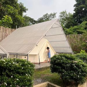 a woman standing inside of a large tent at The Backyard Glamp - Book The Entire Campground 