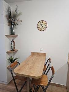 a dining room table with chairs and a clock on the wall at Apartmánový dom Kamzík apt. 16 in Donovaly +14 photos