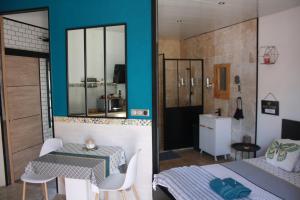 um quarto com uma cama, uma mesa e uma casa de banho em L'instant Détente 34 em Saint-Aunès