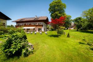 una grande casa in un campo di erba verde di Haus Wolfgangsee a Sankt Gilgen