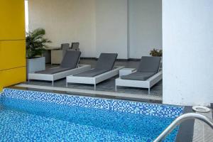 a pool with lounge chairs next to a swimming pool at Central 2 Bed Apartment in Cantonments