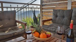 a table with a bowl of fruit and two glasses of wine at Gardenia in ‘Ein el Asad