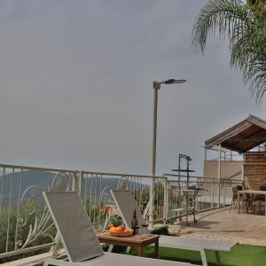 uma vista para o oceano a partir de uma varanda com uma mesa em Gardenia em ‘Ein el Asad