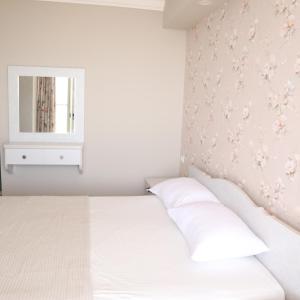 1 dormitorio con cama blanca y espejo en Gardenia en ‘Ein el Asad